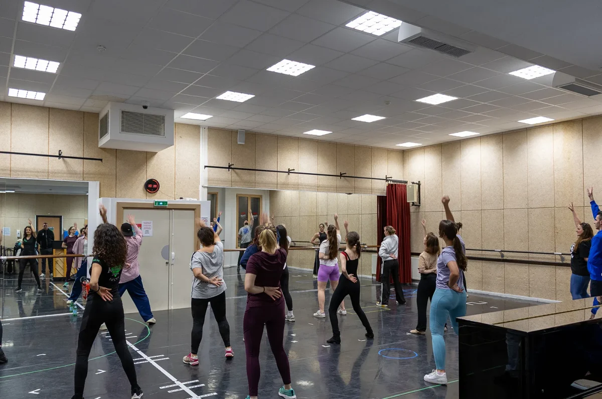 Un groupe profite d'un cours de Dance Party dans un grand studio parisien avec des miroirs et des instructeurs qui enseignent tous les thèmes.